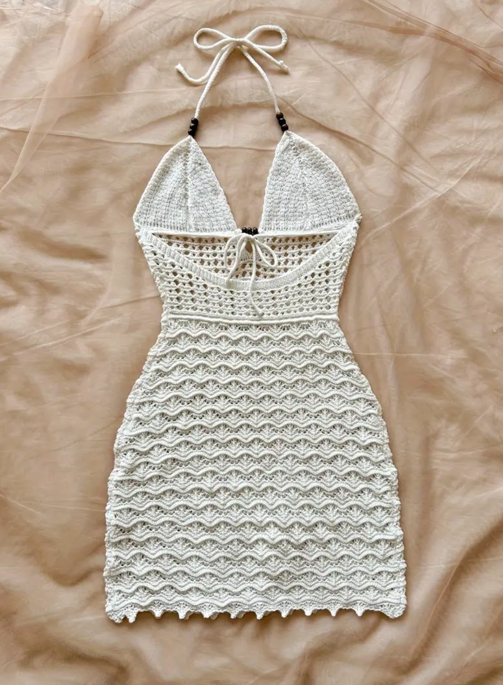 White lace dress on a beige surface